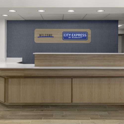 A reception desk in a modern lobby with a city express sign behind it. 140 characters, ending with a period.
